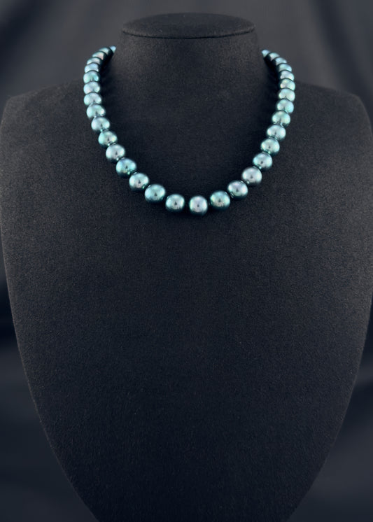 Cultured, Tahitian, green-blue pearl strand necklace, exhibited on black suede, sound reflection, 11-12mm, 16", yellow gold clasp.