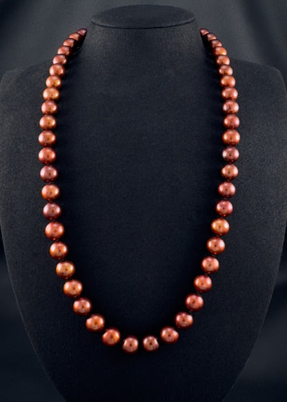 Cultured, South Sea russet-brown pearl continuous strand necklace, exhibited on black suede, excellent reflection, 10.5-11.5mm, 24", no clasp.