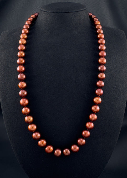 Cultured, South Sea russet-brown pearl continuous strand necklace, exhibited on black suede, excellent reflection, 10.5-11.5mm, 24", no clasp.