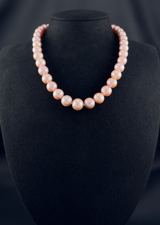 Cultured, South Sea pink pearl strand necklace, exhibited on black suede, excellent reflection, 10-12.5mm, 17.5", sterling silver clasp.