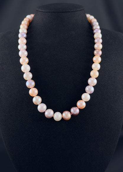 Cultured, South Sea mixed pink pearl strand necklace, exhibited on black suede, excellent reflection, 10.5mm, 20", yellow gold clasp.
