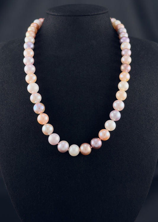 Cultured, South Sea mixed pink pearl strand necklace, exhibited on black suede, excellent reflection, 10.5mm, 20", yellow gold clasp.