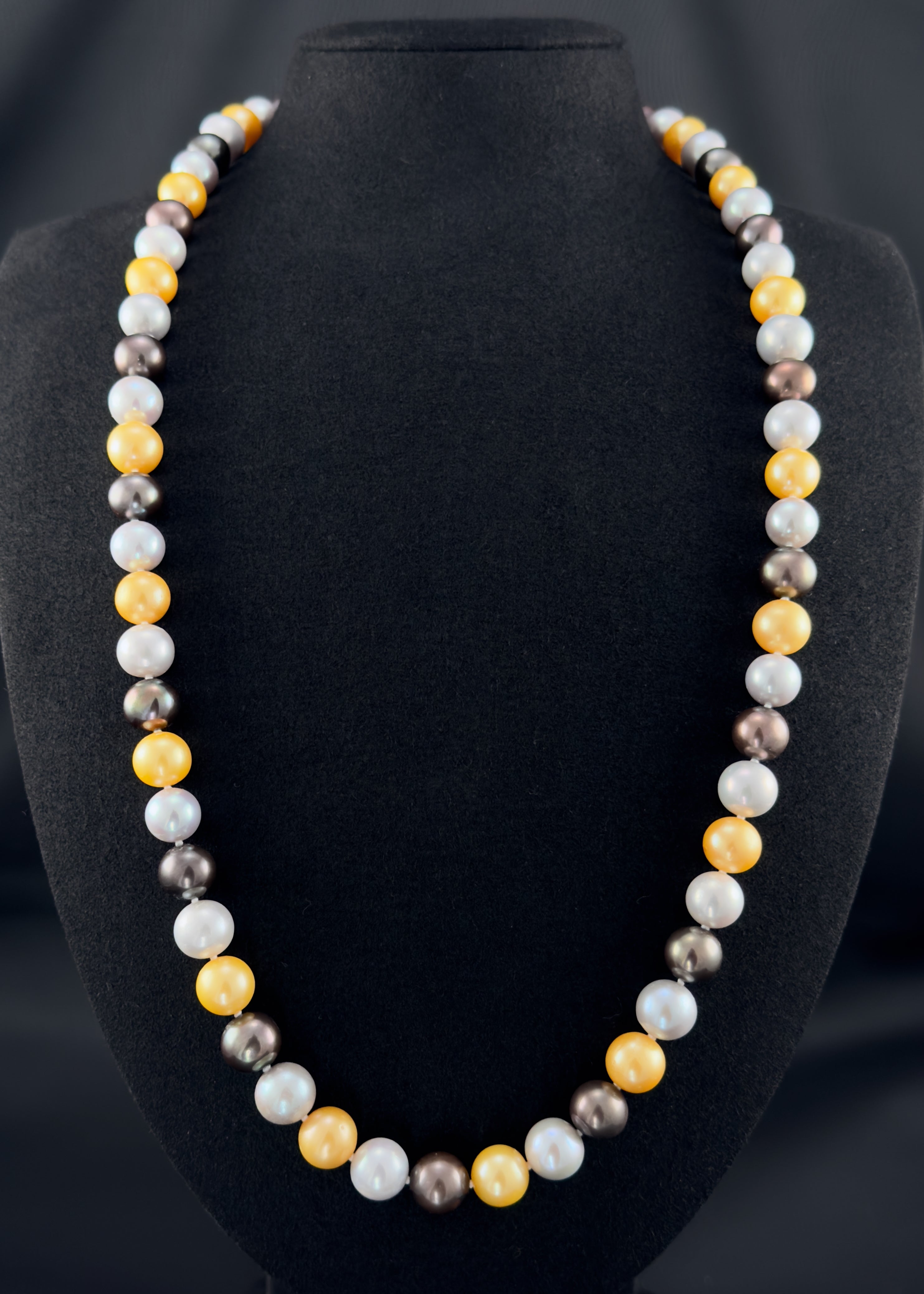 Cultured, South Sea mixed gold-grey-white continuous strand pearl necklace, exhibited on black suede, excellent reflection, 10mm, 26", no clasp.