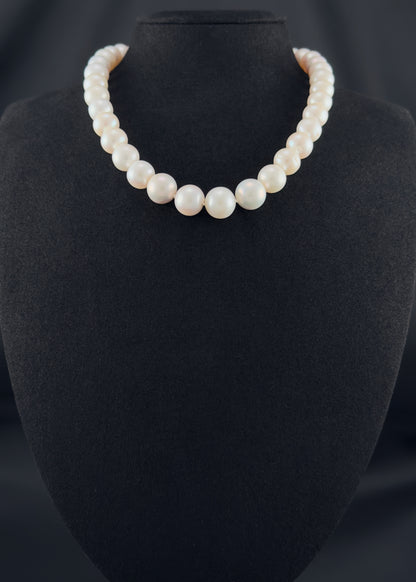 Cultured, South Sea white pearl strand necklace, exhibited on black suede, fair reflection, 9.5-12.5mm, 16", sterling silver clasp.